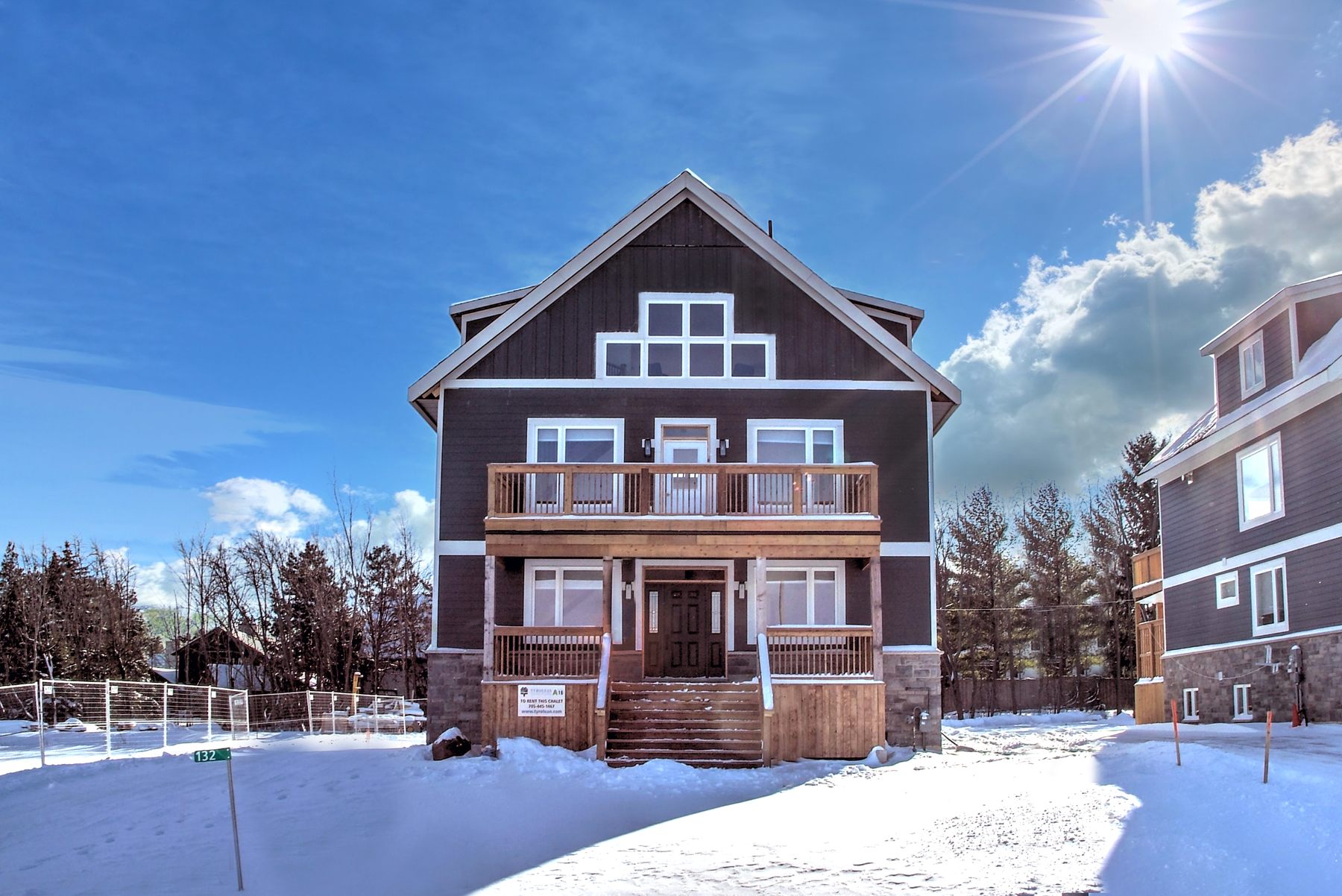 Front of a newly built 7-bedroom luxury chalet rental in the snow at Tyrolean Village Resorts, Blue Mountain